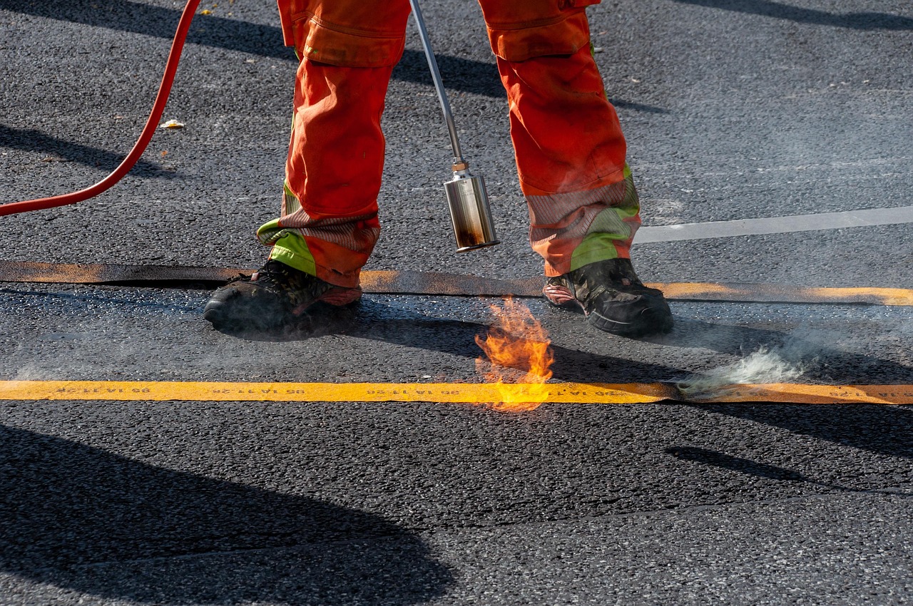 Construction workers repairing an asphalt road, the kind of municipal infrastructure project put out to public tender