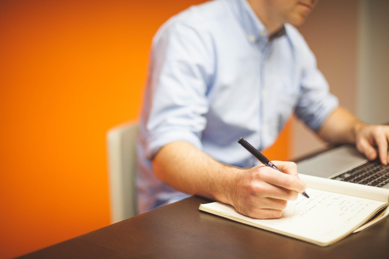 Small business owner working on a laptop at a desk, preparing bid documents