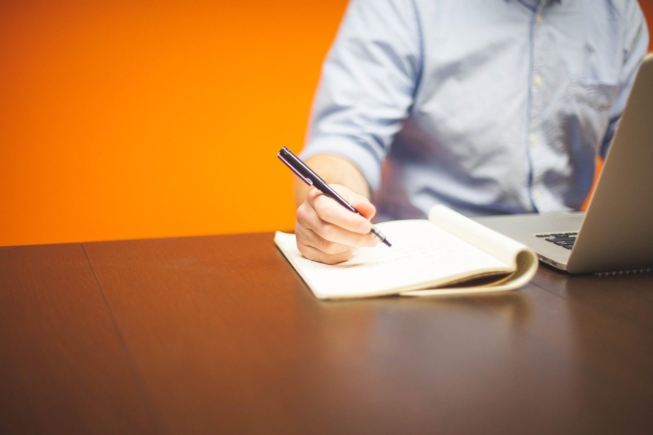 A small business owner reviewing paperwork and a laptop at an office desk