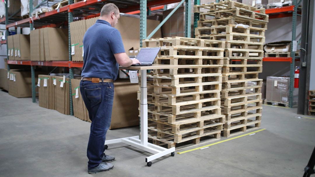 A small business owner in a warehouse checking stock near wooden shelving