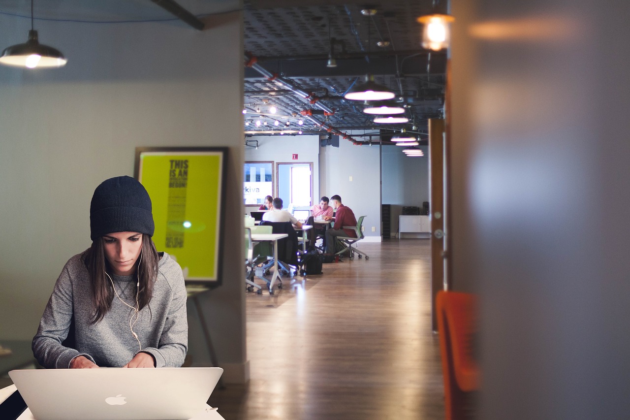 A small business owner typing on a laptop at an office desk