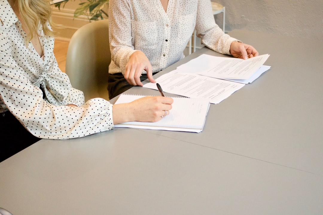Person writing notes while reviewing a document