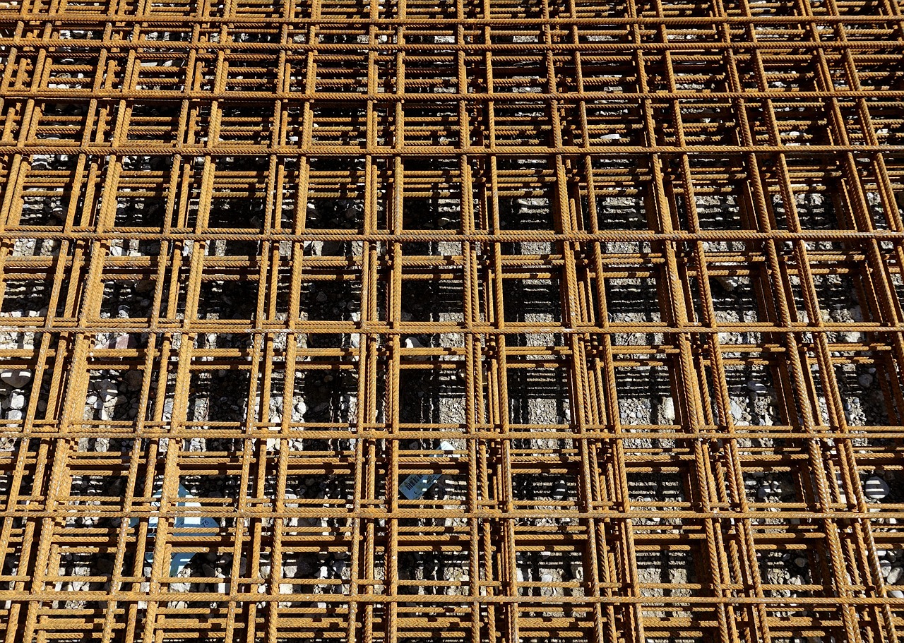 Steel reinforcement beams and rebar stacked at a construction site, materials covered by Canadian-content rules