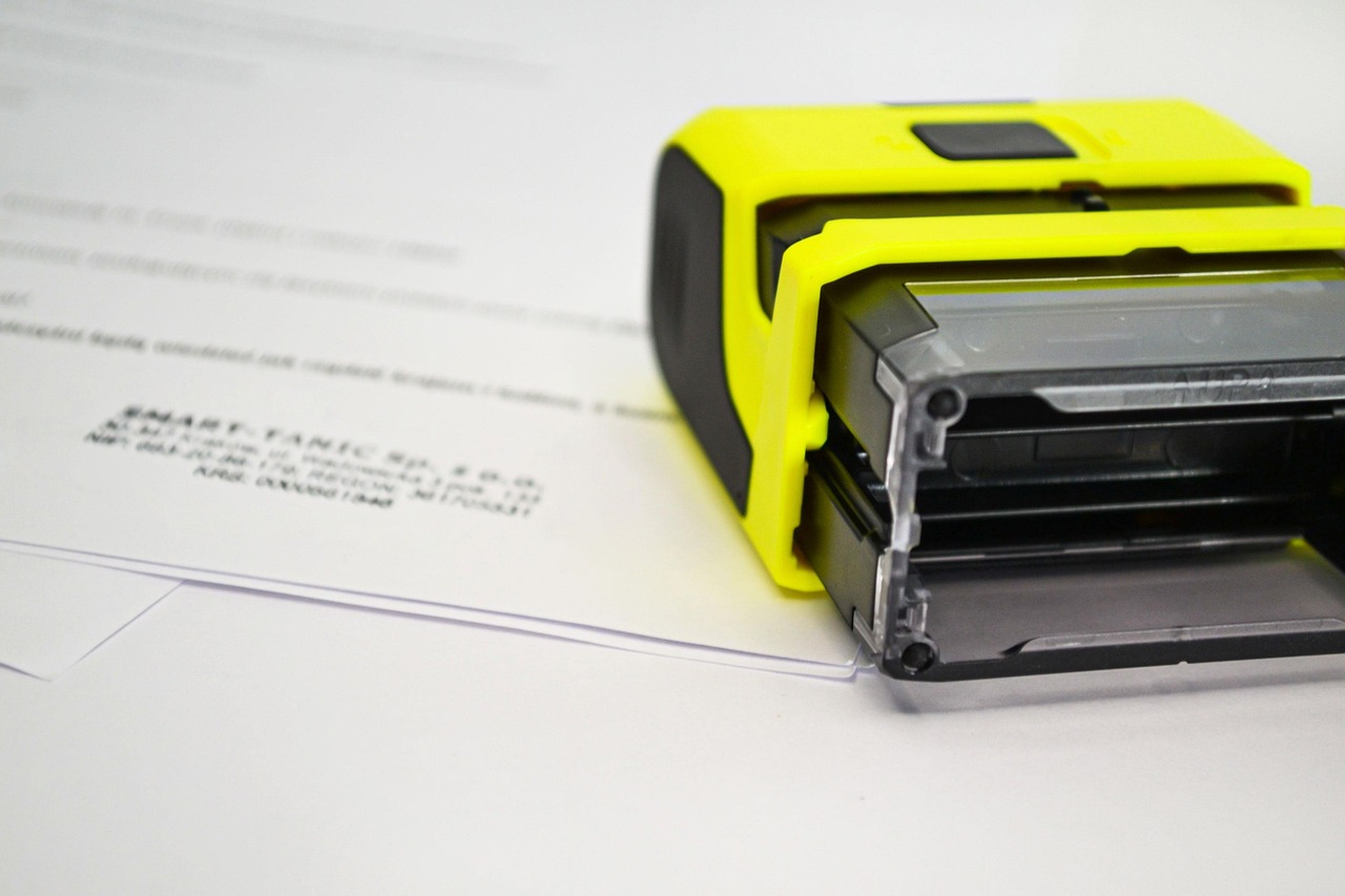 A rubber stamp being pressed onto a paperwork document