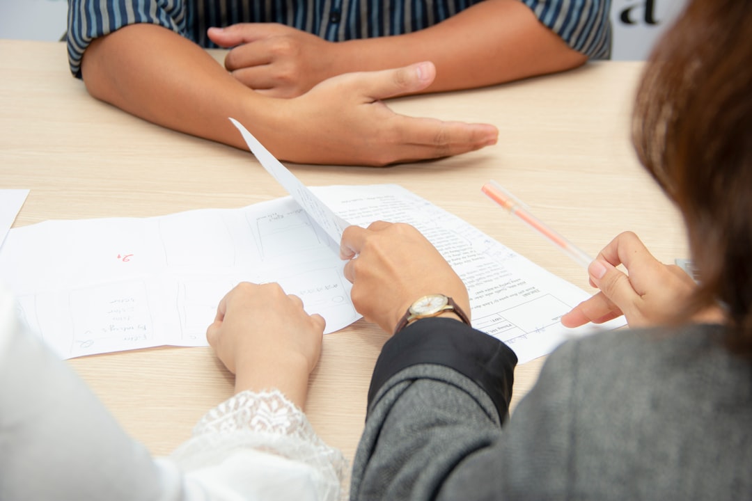Two people sitting at a table reviewing documents together during a meeting