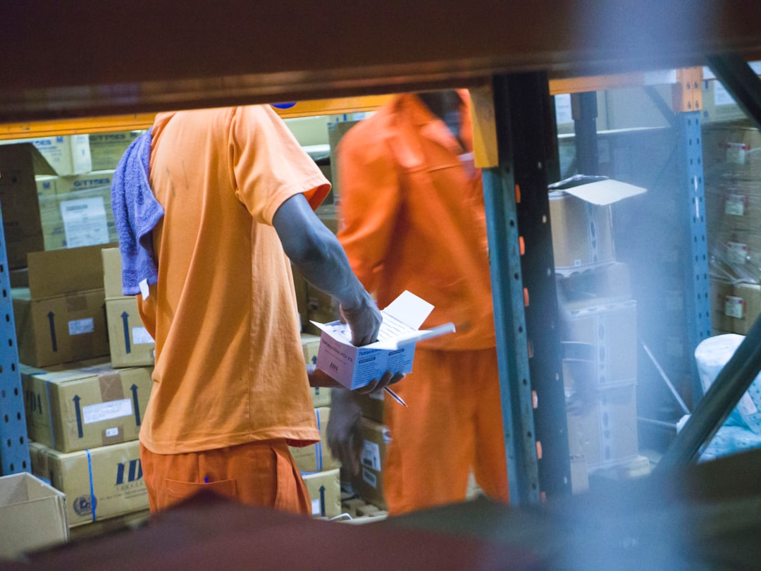 A warehouse worker checking inventory and paperwork on a tablet