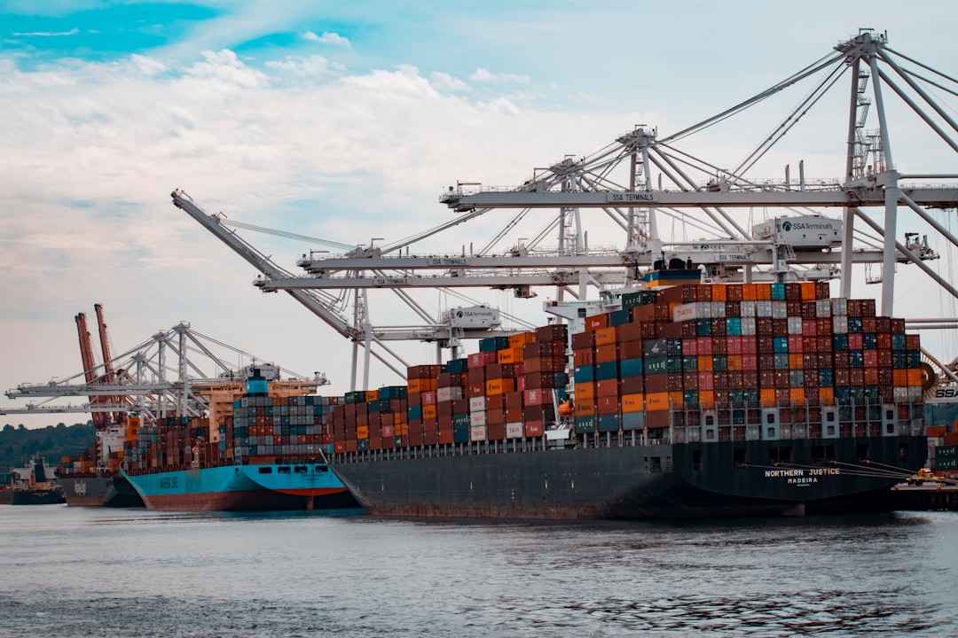 Stacked shipping containers at a busy cargo port