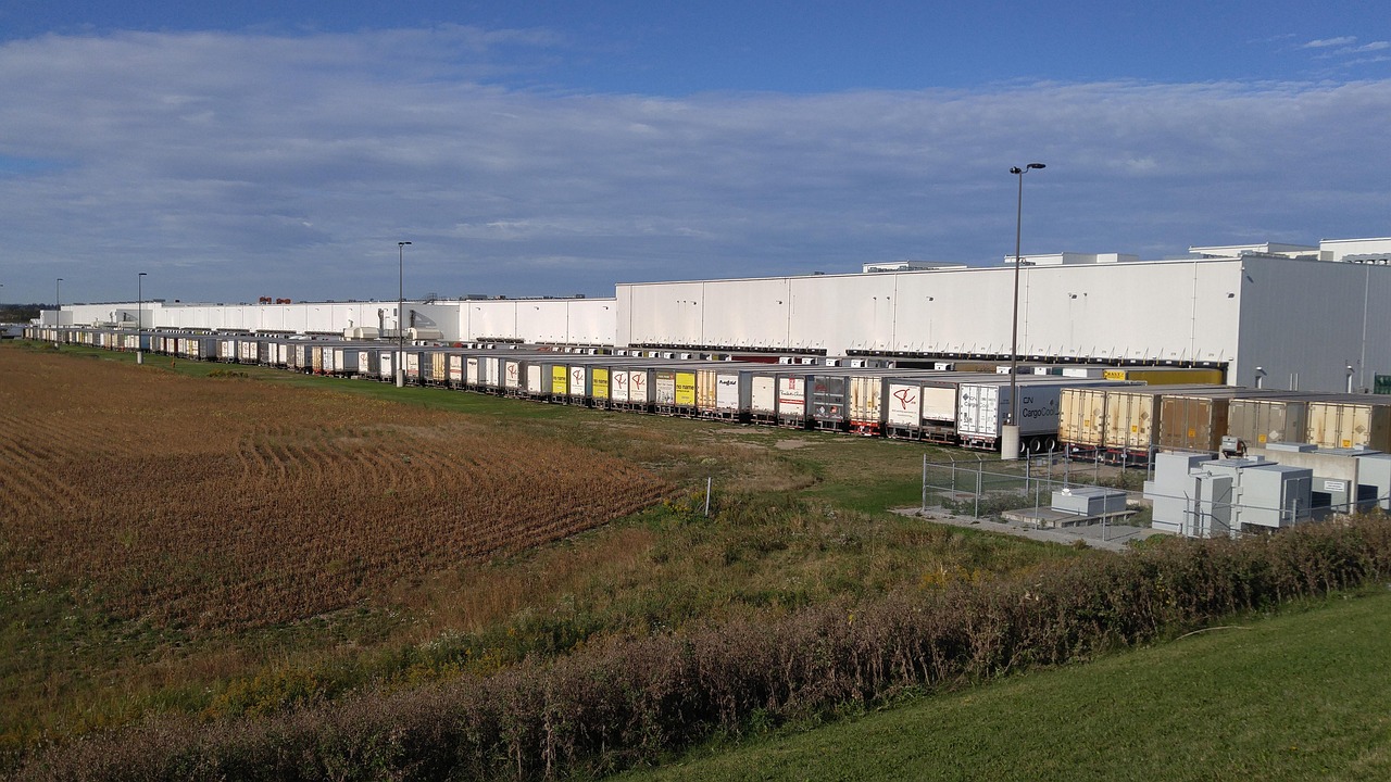 Delivery trucks lined up at a distribution depot loading dock, ready to fulfil orders