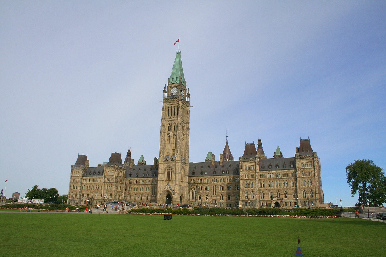 Historic Parliament Hill government buildings in Ottawa under a cloudy sky