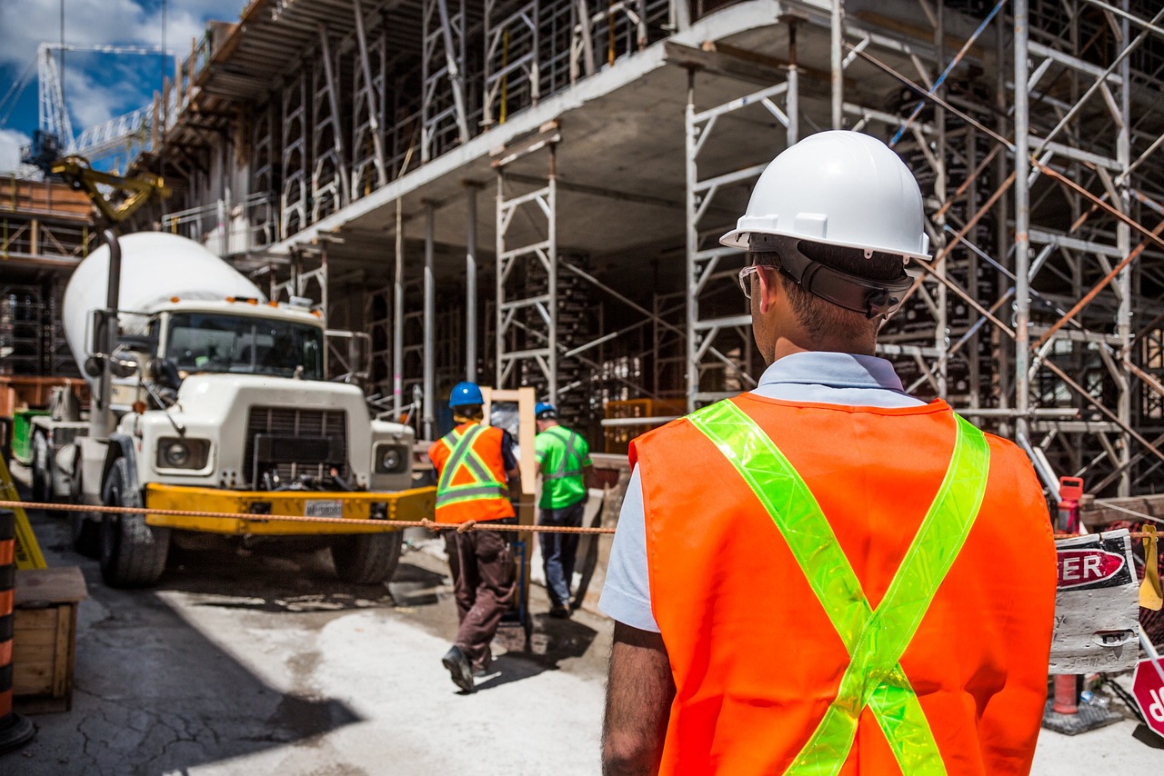 Contractor in a hard hat and safety gear working on a small construction site