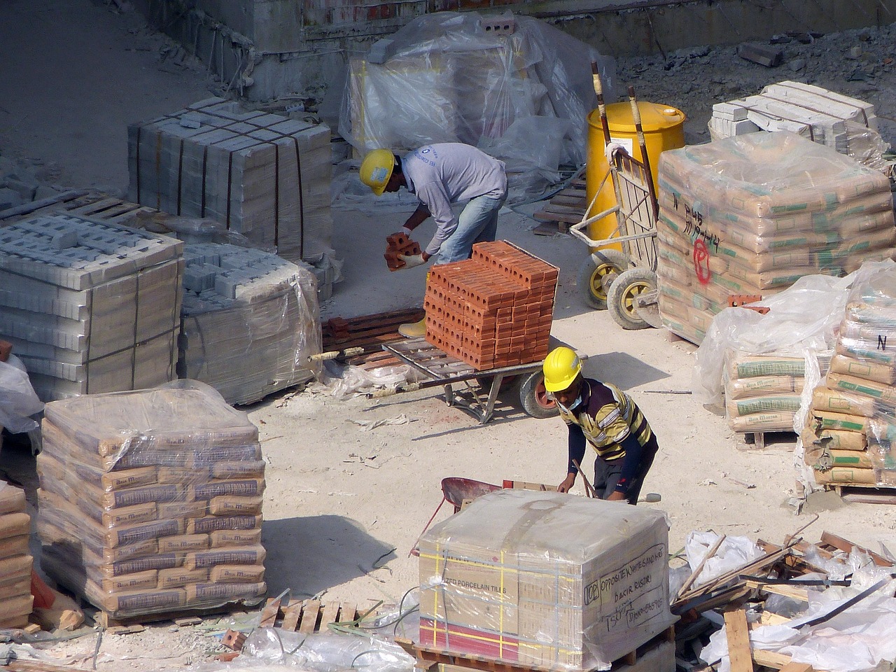 Construction worker in a hard hat and safety vest on an active building site