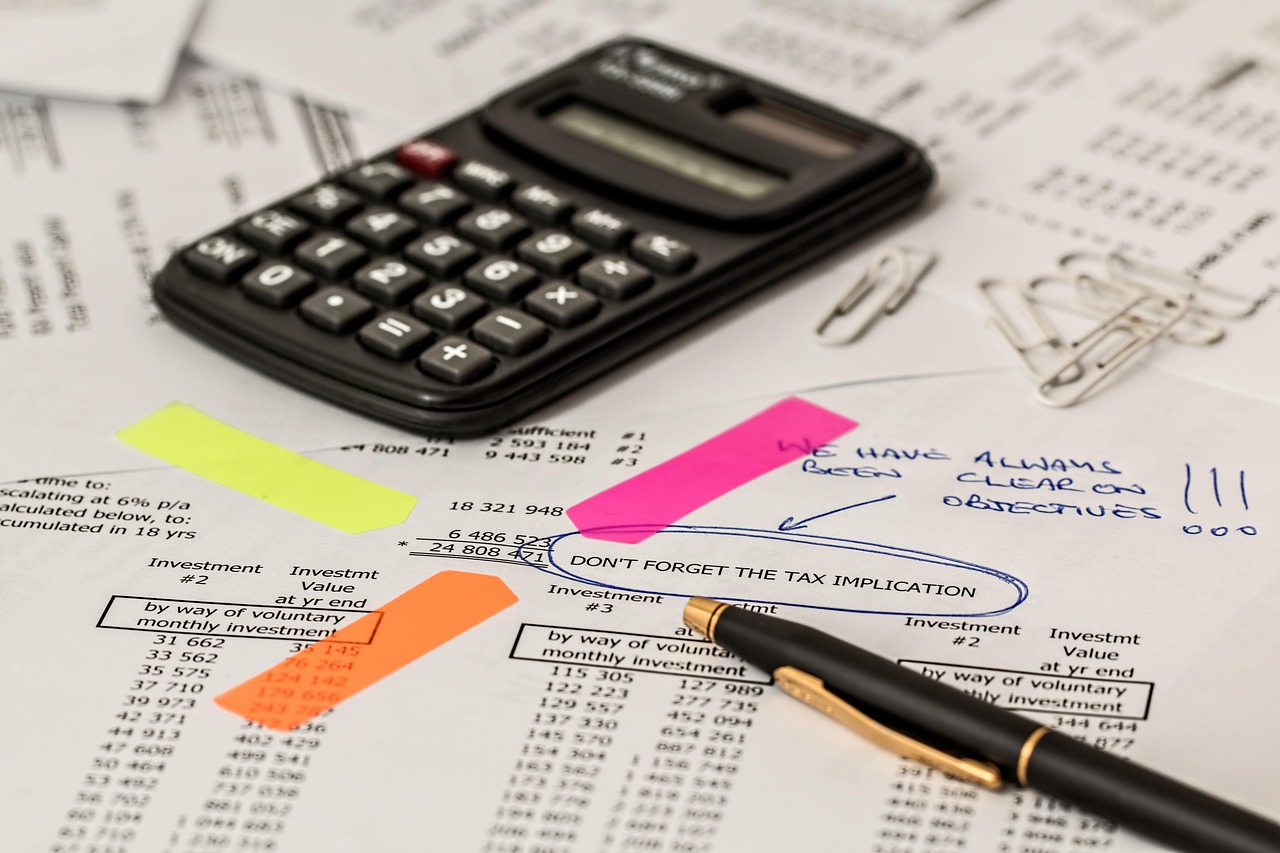 Calculator, pen and insurance paperwork spread across a desk