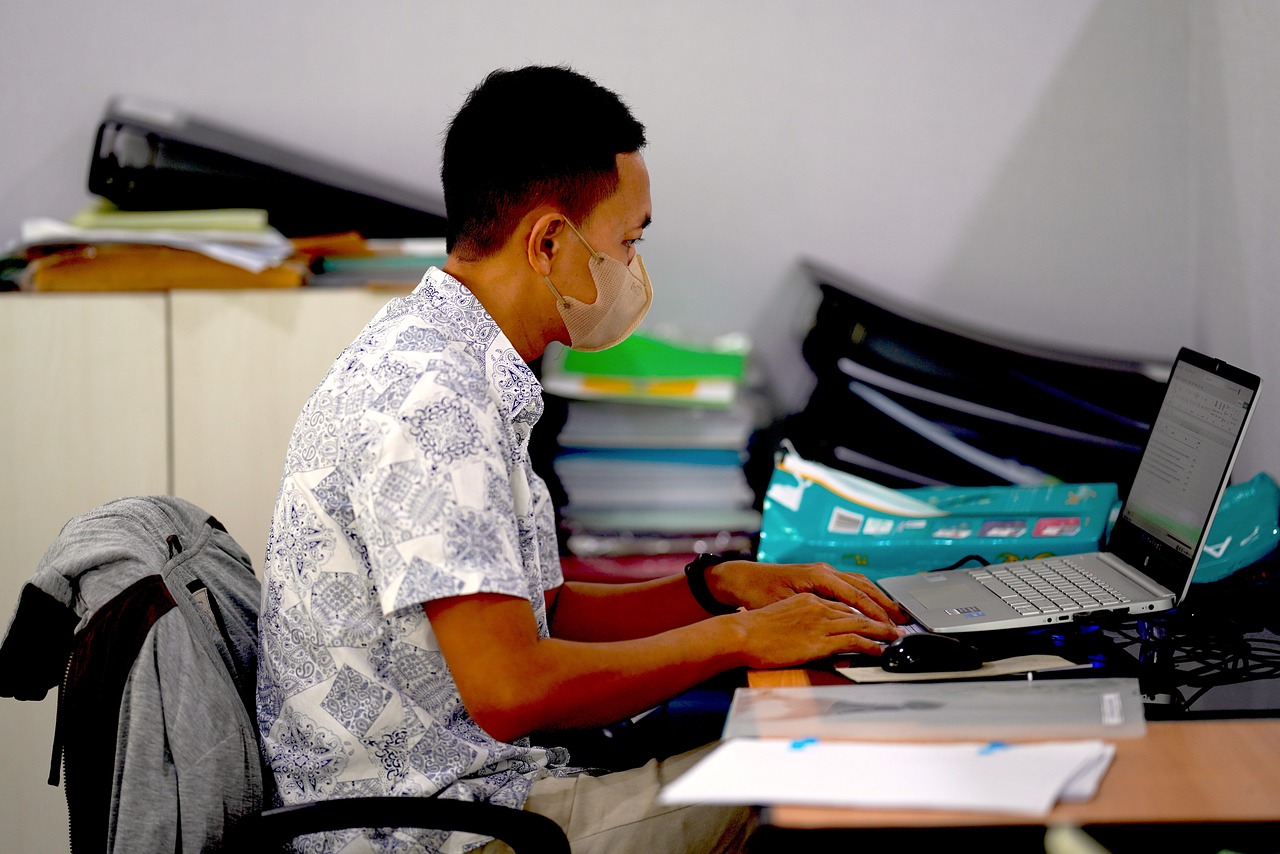 A small business owner working at a desk with a laptop, reviewing documents