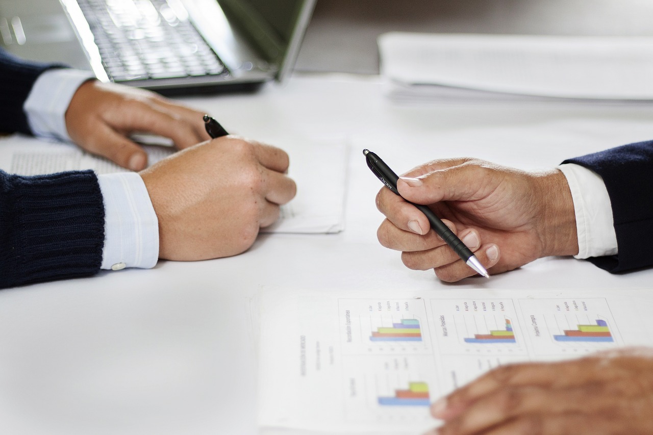 Two people shaking hands after reaching an agreement over a signed contract document