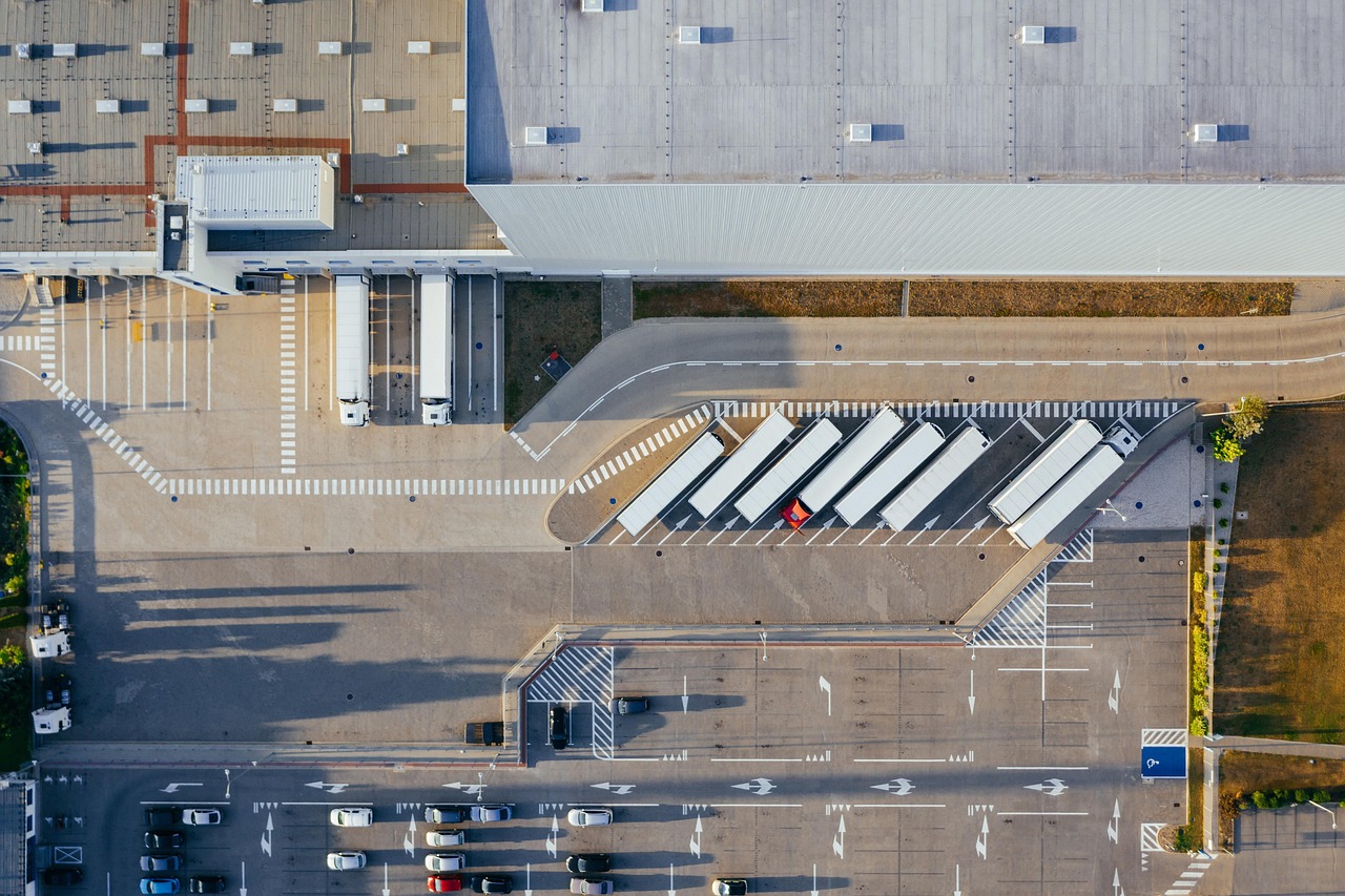 Aerial view of a distribution warehouse with trucks loading at the dock bays