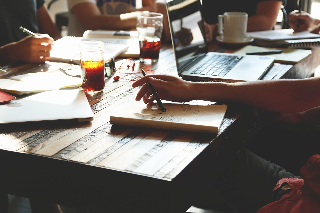 Small business owner working at a laptop on an office desk covered with paperwork