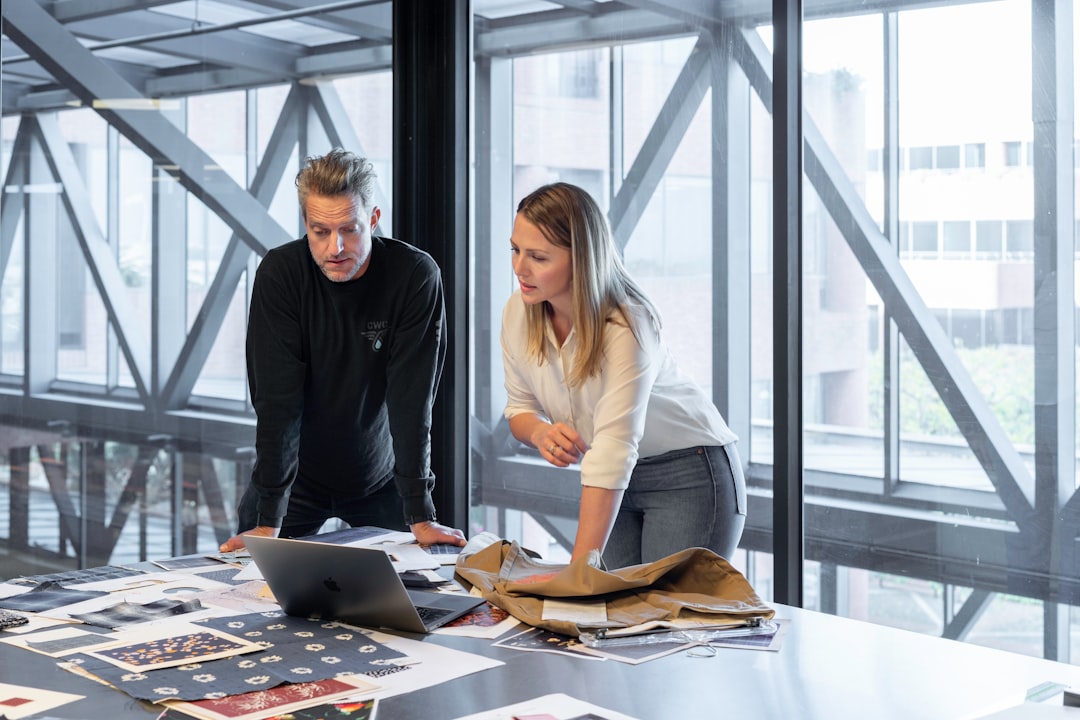 Two people sitting at a table reviewing documents together during a business meeting